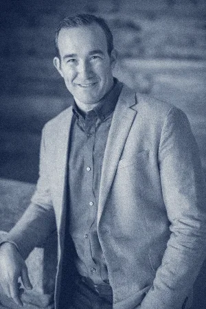 Scott Juranek, smiling, in a grey blazer and blue shirt